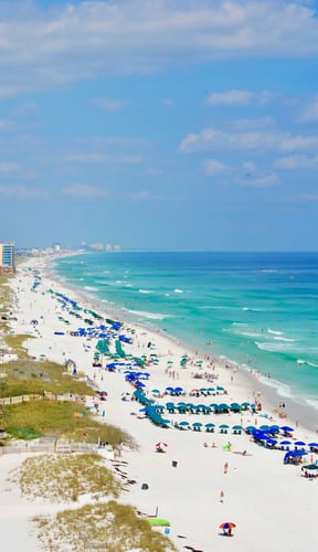 Aerial view of a Florida beach with turquoise water and colorful umbrellas