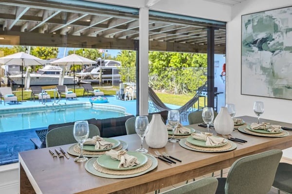 Covered outdoor dining area with pool and canal views