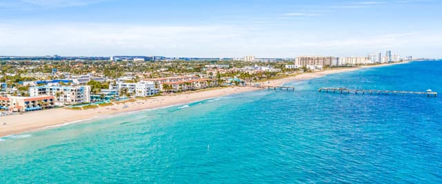Aerial view of turquoise Florida beach water meeting white sand at sunrise